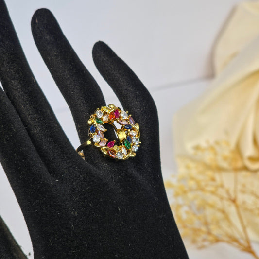 Multicolored gemstone ring on a black glove with a floral background