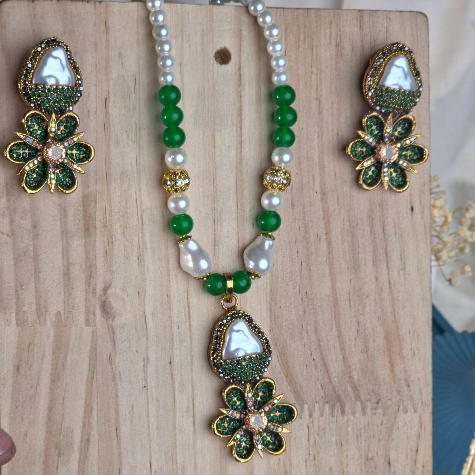 Jewelry set with floral and beaded design on a wooden block