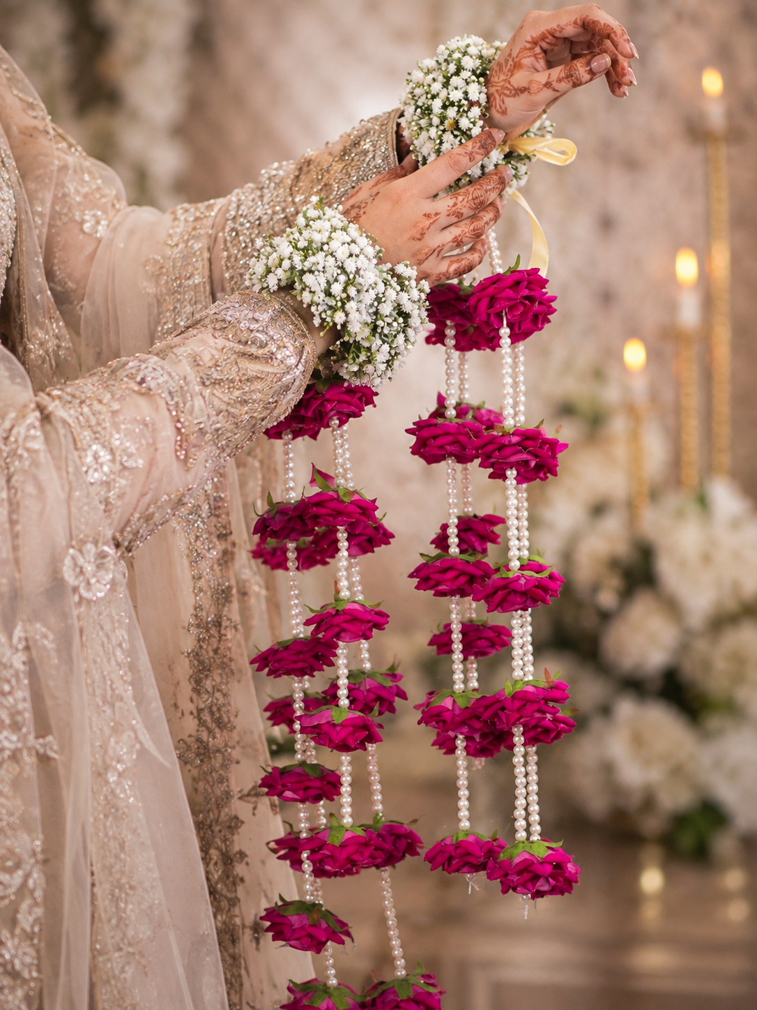 Handcrafted long fuchsia floral kaleera pair with white pearls and cascading pink flower details for colourful bridal celebrations.


