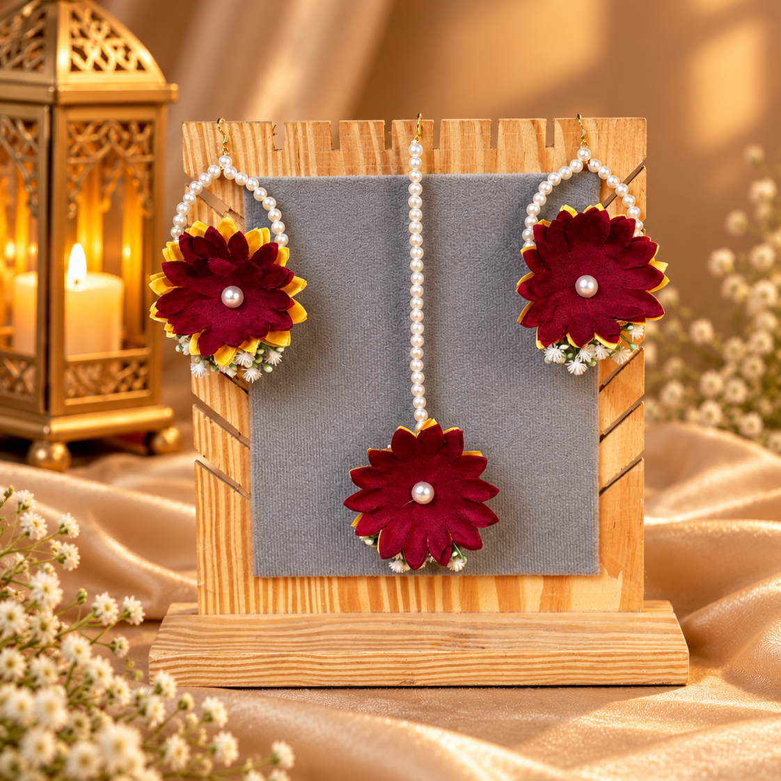 Matching floral earrings and tikka featuring maroon and yellow flowers, delicate pearl loops and white floral details, created to complete a festive Pakistani bridal Mehndi look.