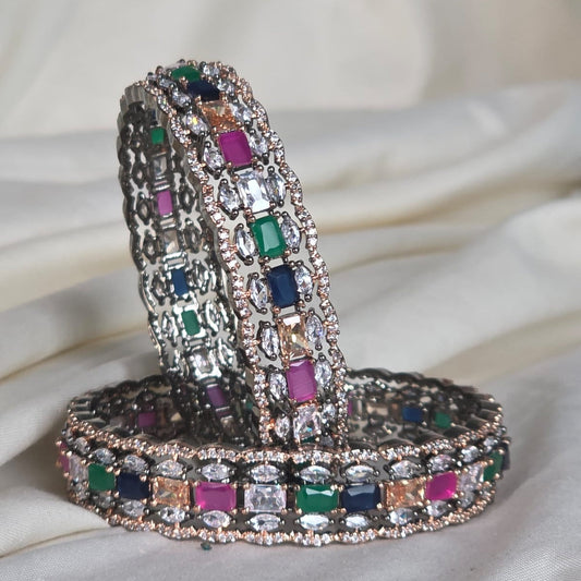 Decorative snake-shaped object with multicolored gemstones on a white fabric background
