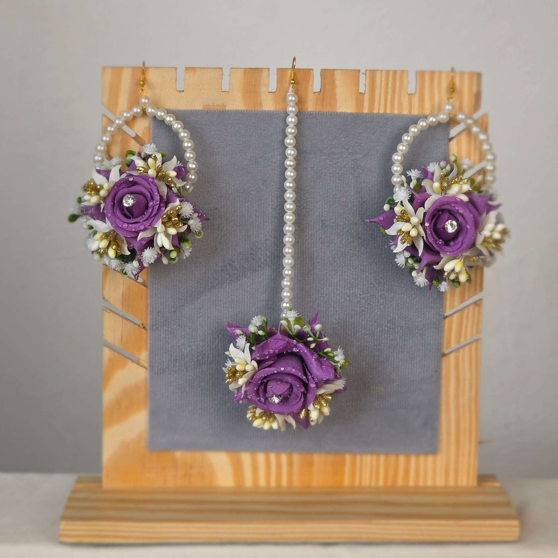 Set of purple flower k artificial flower earrings worn by a mehndi bride.