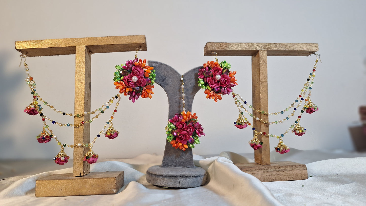 A detailed close-up shot showing the variety of vivid artificial focal flowers, elegant tracking chains, and matching bindiya on the Colour Bloom set.