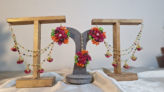 A detailed close-up shot showing the variety of vivid artificial focal flowers, elegant tracking chains, and matching bindiya on the Colour Bloom set.