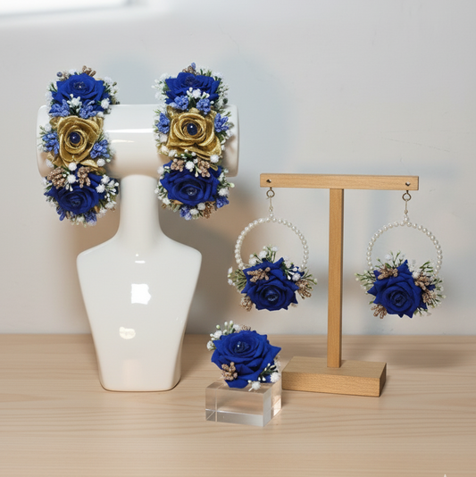 Set of blue and gold floral earrings displayed on a mannequin bust and wooden stand.