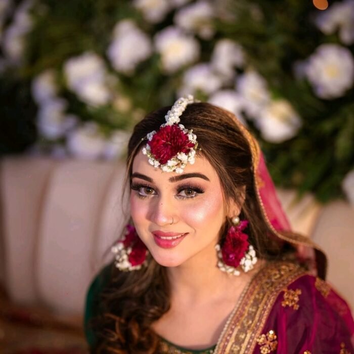 Maroon and white floral jewelry is meticulously crafted using chrysanthemums and baby’s breath.